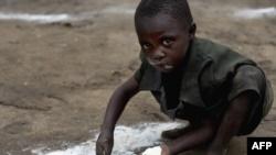 Ребенок в Конго собирает муку с земли. Архивное фото.