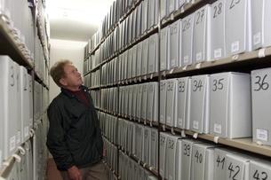 Uomo osserva scatole d'archivio