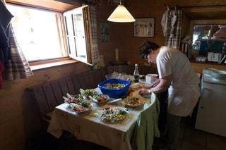 The hut ward assistant prepares salad for the guests in the kitchen of the Saseo mountain hut.