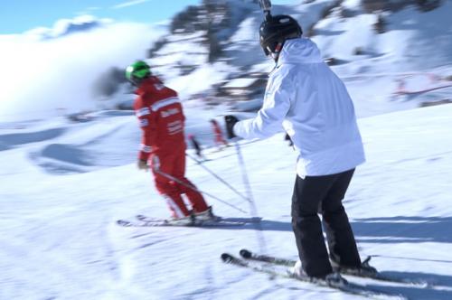 Woman skiing behind indtructor