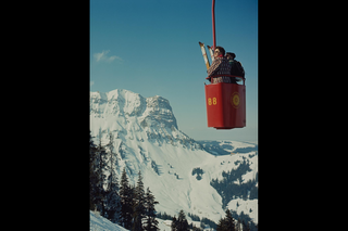 Open-air cable car carrying two people.