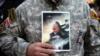 Иранский военный на демонстрации в память о погибшем Касеме Сулеймани, с его портретом в руках. Тегеран, 3 января 2020 года